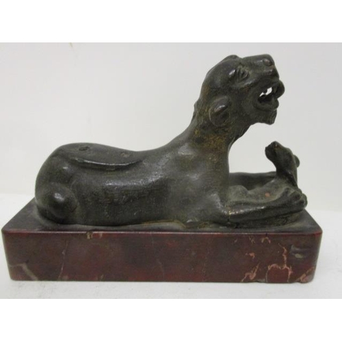 296 - An early 19th century Indian cast bronze model of a lion with a fawn, on a red marble base, 3 3/4