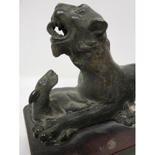 296 - An early 19th century Indian cast bronze model of a lion with a fawn, on a red marble base, 3 3/4