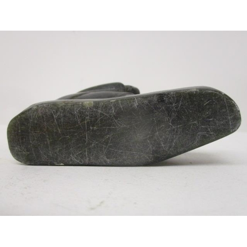 298 - A Canadian carved, green soapstone figure of an Inuit catching a fish through a hole in the ice, 3 1... 