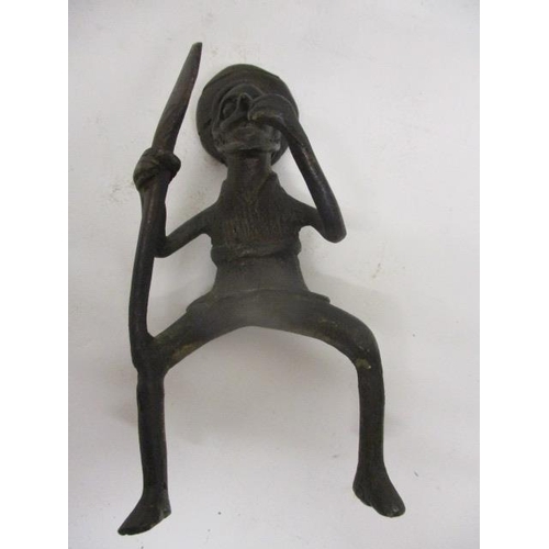 299 - A 19th century, possibly African, cast bronze model of a man holding a spear, wearing a head wrap, o... 