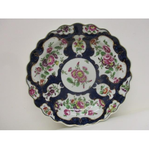 70 - A late 18th century Worcester plate with a lobed edge decorated with panels of flowers on a scale bl... 