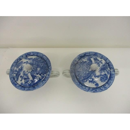 74 - A pair of Pearlware blue and white custard cups, with domed covers and twin handles, decorated with ... 