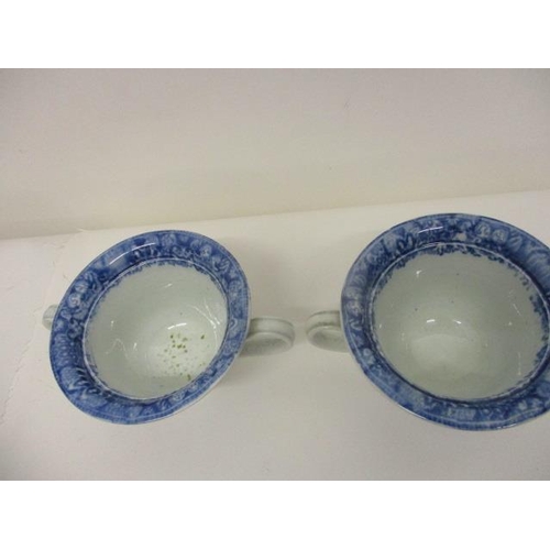 74 - A pair of Pearlware blue and white custard cups, with domed covers and twin handles, decorated with ... 