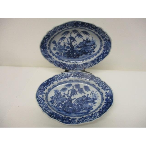 78 - A pair of late 18th century Chinese blue and white oval dishes decorated with a tree, flowers and ob... 