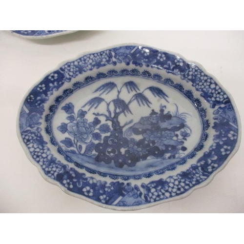 78 - A pair of late 18th century Chinese blue and white oval dishes decorated with a tree, flowers and ob... 