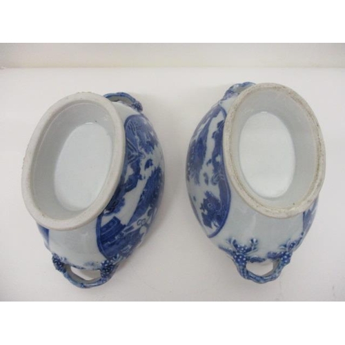 79 - A pair of mid 18th century Chinese blue and white oval tureens with twin crossover handles on a spla... 