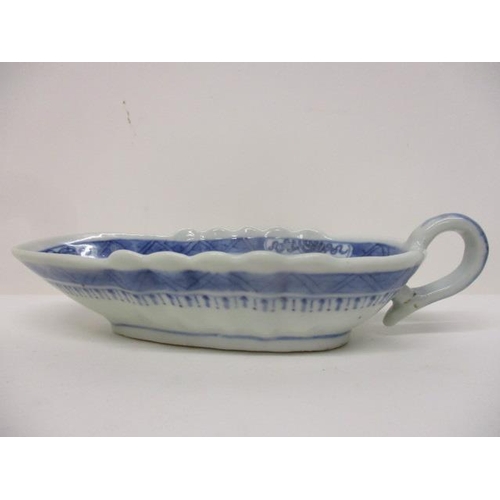 83 - An early 19th century Chinese Canton blue and white sauce boat decorated with a river scene and buil... 