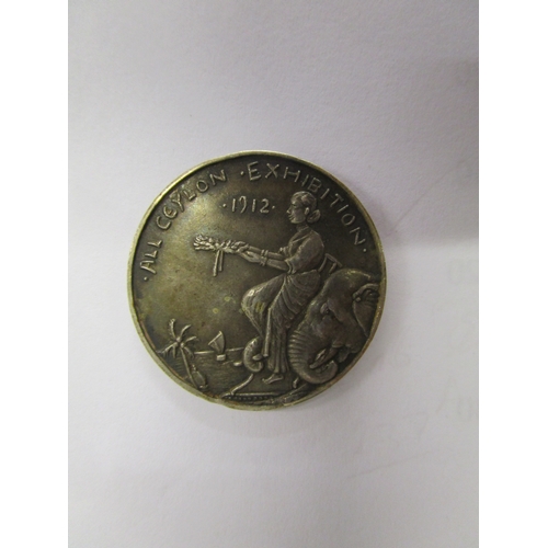 131 - An All Ceylon Exhibition 1912 silver medal, the reverse depicts a Ceylonese girl sitting on an eleph... 