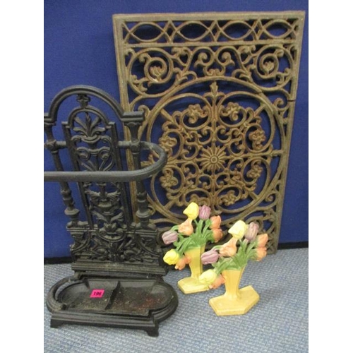 196 - A wrought iron umbrella stand, two modern iron door stops and a wrought iron panel