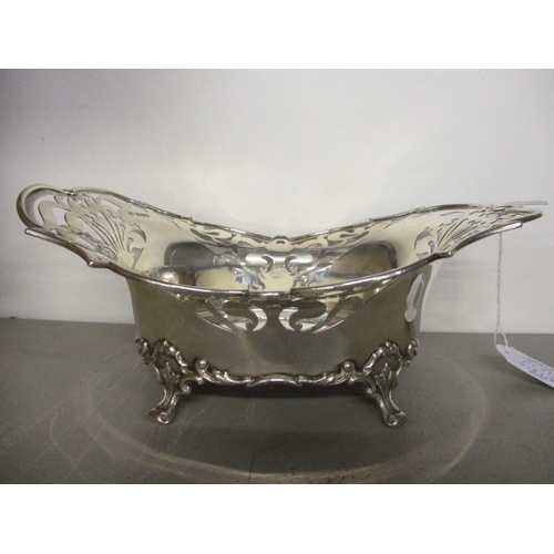 70D - An early 20th century silver bread basket having a pierced border and standing on four scrolled feet... 