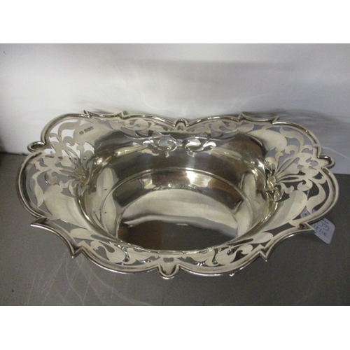 70D - An early 20th century silver bread basket having a pierced border and standing on four scrolled feet... 