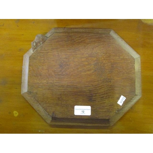 12 - Robert Thompson of Kilburn, a Mouseman oak bread board, octagonal shape with moulded edge, carved si... 