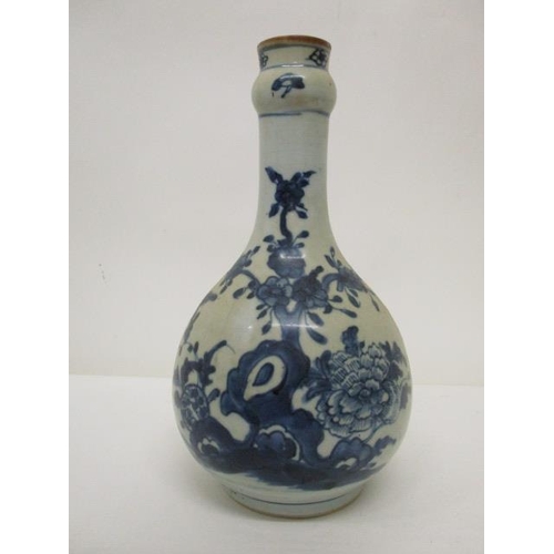 171 - An 18th century provincial Chinese bottle vase decorated with a flowering tree and plants, in blue o... 