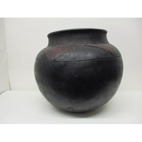 180 - A 19th century South African black, brown/red glazed clay pot with incised decoration, 14