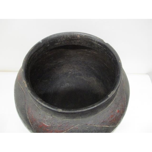 180 - A 19th century South African black, brown/red glazed clay pot with incised decoration, 14