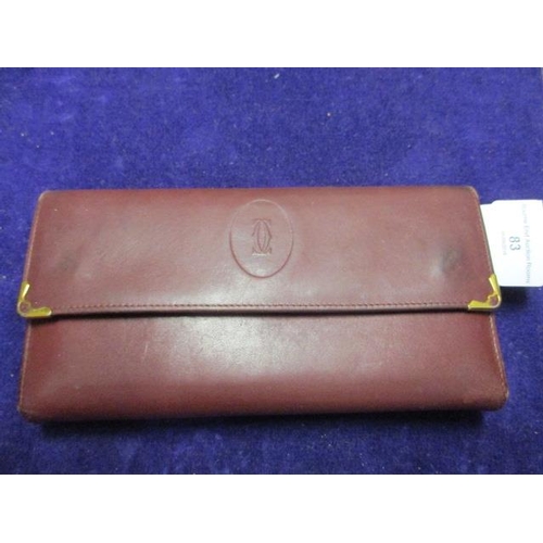 83 - A vintage Cartier leather purse in Bordeaux red