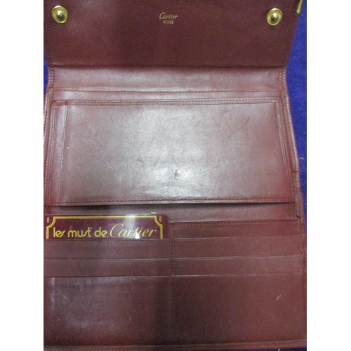 83 - A vintage Cartier leather purse in Bordeaux red