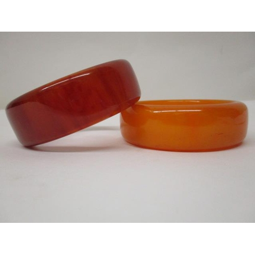 174 - Two Bakelite bangles, one egg yolk coloured and the other a pale brown, 125g