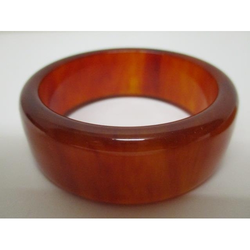 174 - Two Bakelite bangles, one egg yolk coloured and the other a pale brown, 125g