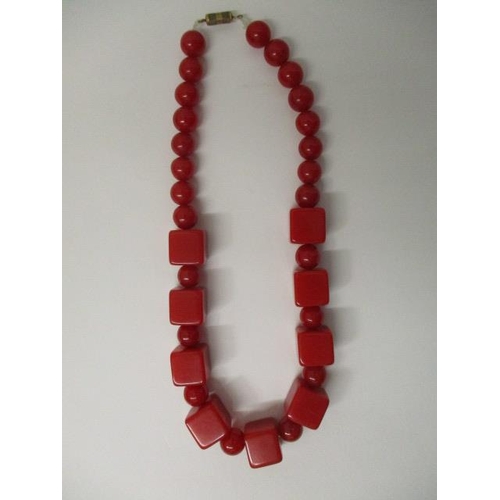 175 - A red Bakelite necklace with nine square and twenty four round beads, 69g