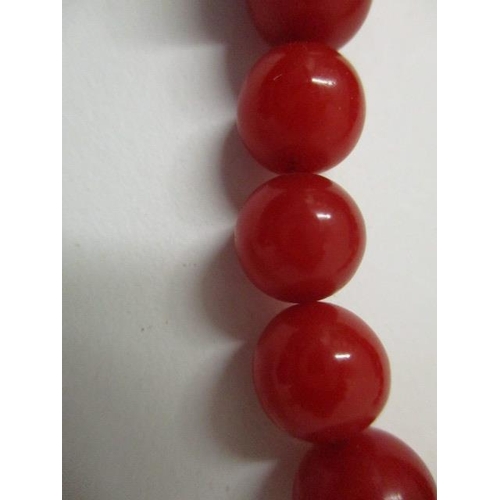 175 - A red Bakelite necklace with nine square and twenty four round beads, 69g