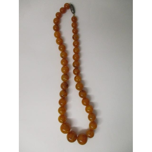 176 - An egg yolk coloured Bakelite necklace with thirty seven beads, 141g