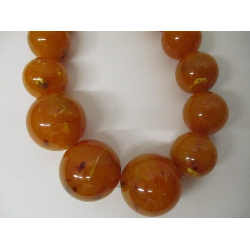 176 - An egg yolk coloured Bakelite necklace with thirty seven beads, 141g