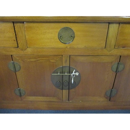 244 - A Chinese oak scroll desk with three short drawers and cupboards below flanked by pierced floral bra... 