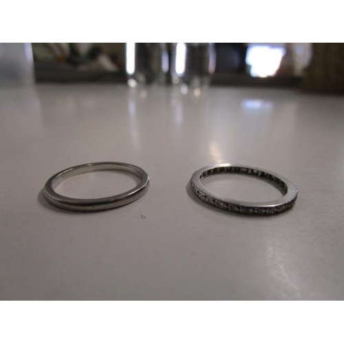 313 - A white metal diamond full eternity ring, along with a white metal (possibly platinum) wedding band,... 