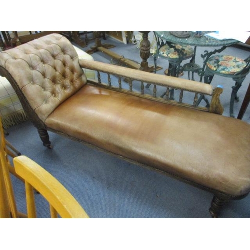 240 - A Victorian walnut chaise longue upholstered in brown leather with a spindle back on turned legs