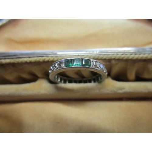 312 - A white metal diamond and emerald full eternity ring, weight 2.9g