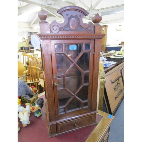 352 - A late Victorian/Edwardian table display cabinet with carved pediment, flanked by turned finials, ab... 