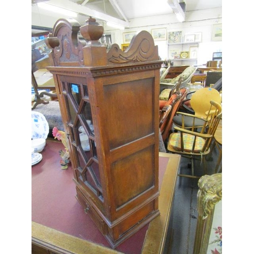 352 - A late Victorian/Edwardian table display cabinet with carved pediment, flanked by turned finials, ab... 