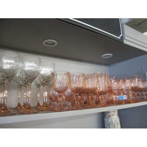 383 - A quantity of pink and pink stemmed drinking glasses to include twelve water glasses and twelve wine... 