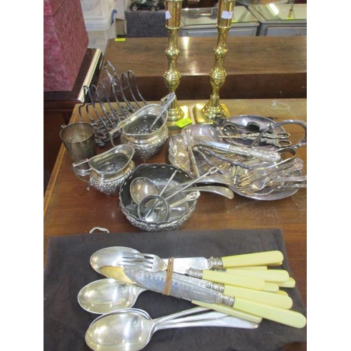 172 - A pair of brass candlesticks and mixed silver plate to include grape scissors and a toast rack