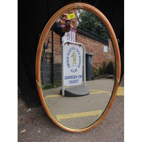 206 - An oval wall hanging mirror having gilt highlights