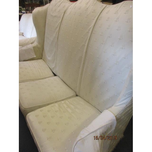 300 - A Queen Anne style high backed three-seater sofa with mahogany short legs in a cream upholstery depi... 