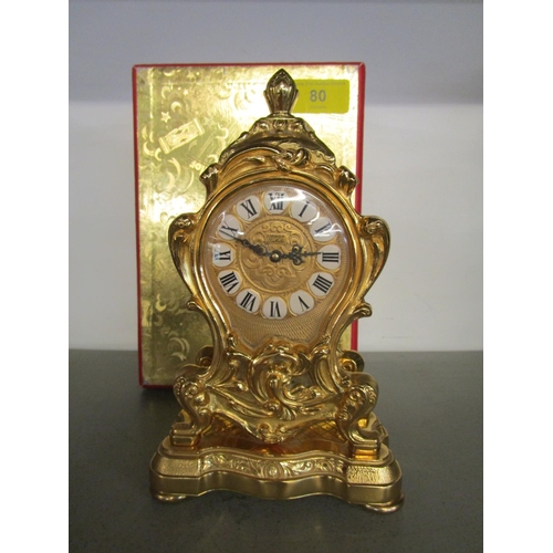 80 - An Imhof Jubilee gold metal cased mantel clock in the Louis XV style, in original box