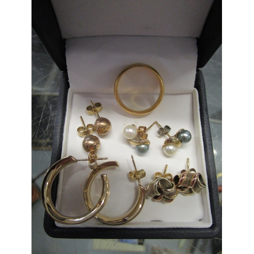 82 - A 22ct gold wedding band, 9ct gold hoop earrings and two 9ct gold ear studs, along with a gold colou... 