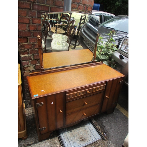 70 - A mid 20th century oak dressing table having three central drawers flanked by two cupboard doors 53