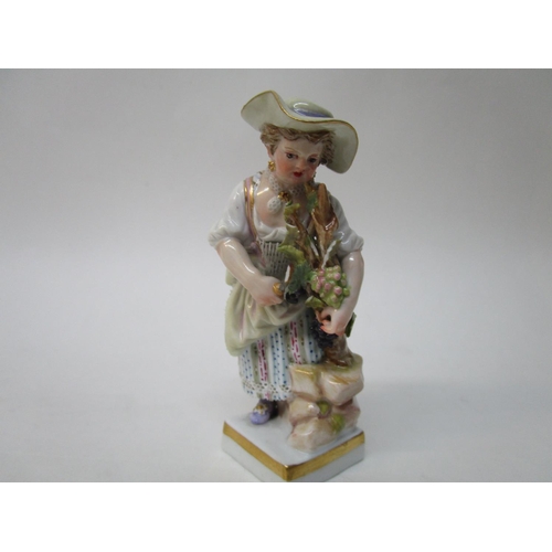 182 - A Meissen figure of a girl picking grapes, on a plinth with a blue factory mark, inscribed 68, 121, ... 