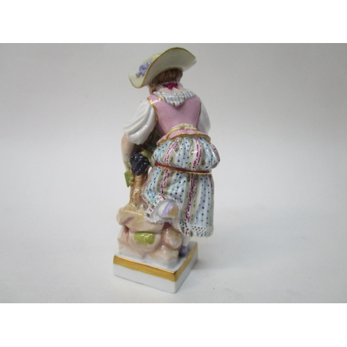 182 - A Meissen figure of a girl picking grapes, on a plinth with a blue factory mark, inscribed 68, 121, ... 