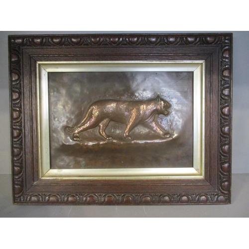 180 - An Arts & Crafts copper plaque decorated with a jaguar in a carved oak frame, 8