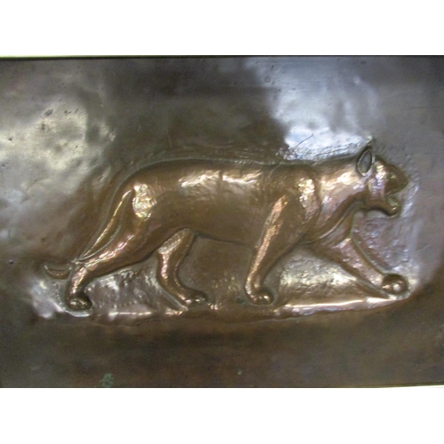 180 - An Arts & Crafts copper plaque decorated with a jaguar in a carved oak frame, 8