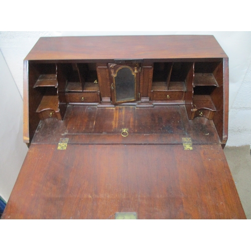 366 - An early 18th century walnut bureau with a feather and crossbanded fall flap enclosing a well, pigeo... 