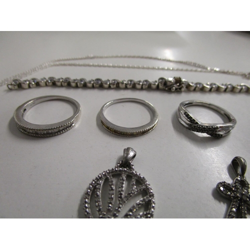 127 - A group of silver set and diamond pendants, silver and diamond set rings, a silver cross set with re... 