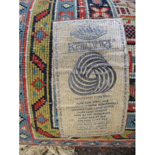 104 - An Indian carpet with repeated boteh on a cream ground within a red, blue and yellow border 100