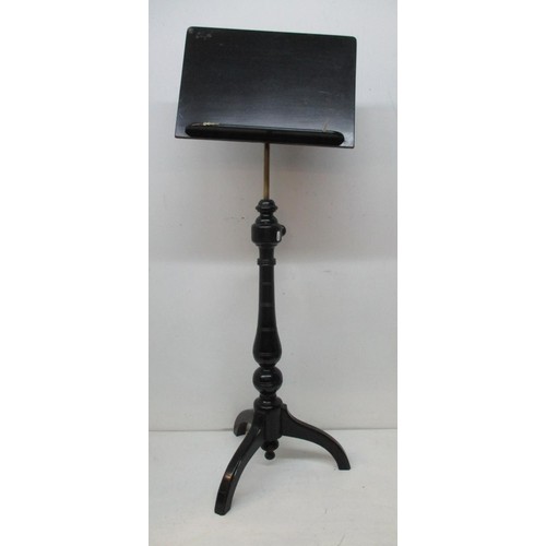 228 - A Victorian ebonized music stand with an angle adjustable panel over a height adjustable brass colum... 