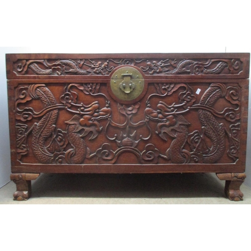 46 - An early 20th century Chinese hardwood chest, the top, front and sides carved with dragons and cloud... 