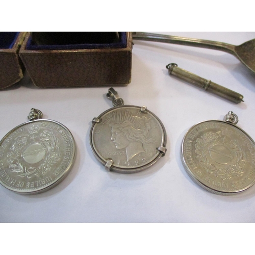 256 - A quantity of small silver items to include a cased napkin ring, a 1922 silver dollar, mounted with ... 